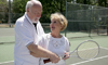 A woman and man smiling as they play tennis